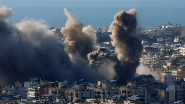 Large cloud of black and grey smoke emerges from among houses in Beirut following a strike