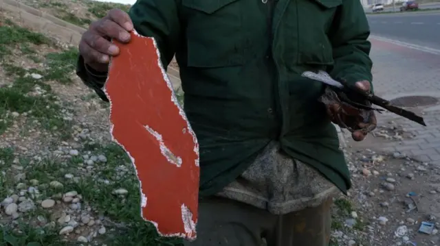 A man shows shrapnel after an Iranian drone attack on Erbil on Saturday