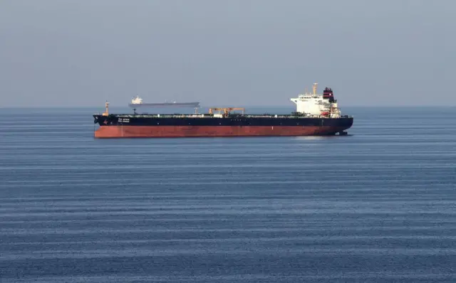 Two large tankers, one further in the distance, in a deep blue sea