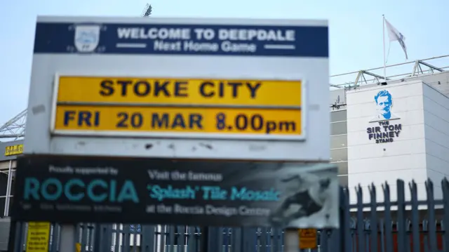 A sign outside Deepdale showing their fixture against Stoke City with the Sir Tom Finney Stand in the background