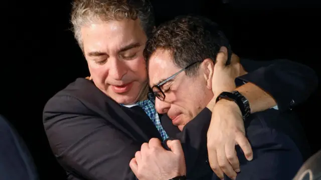 a man hugging and holding the face of Namazi