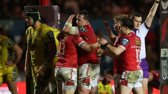 Macs Page of Scarlets celebrates scoring a try with team mates