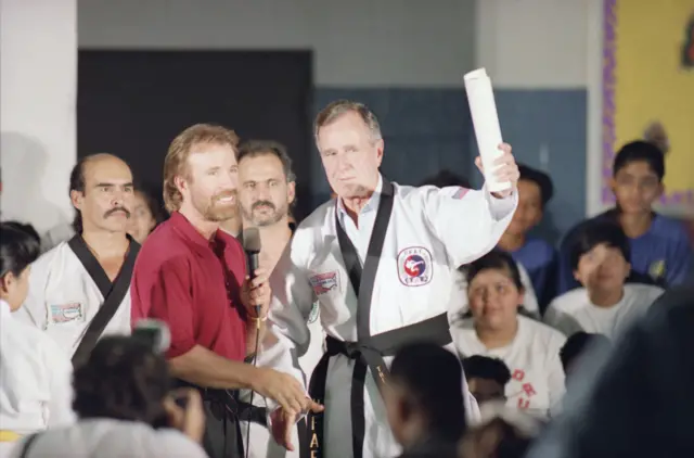 Norris and Bush with schoolkids in karate uniform