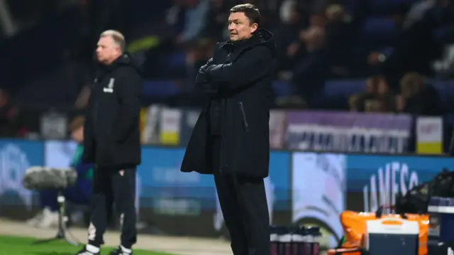 Preston boss Paul Heckingbottom stands on the touchline with Mark Robins in the background