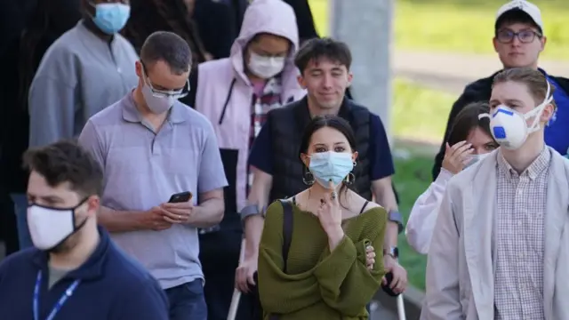 Students queuing to receive vaccines and antibiotics at the University of Kent campus in Canterbury. A number are wearing masks
