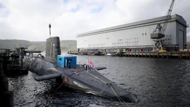 A submarine with a Union Flag is docked