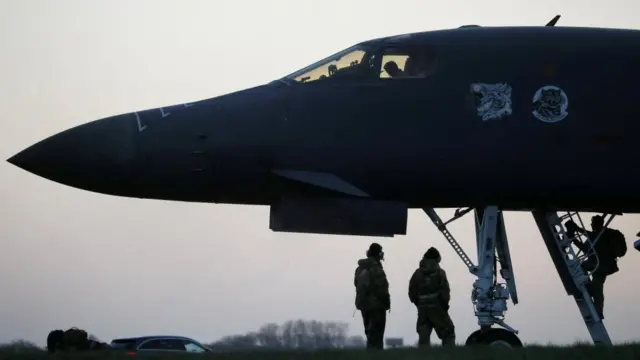 A crew member boards a USAF B-1B bomber at RAF Fairford airbase.