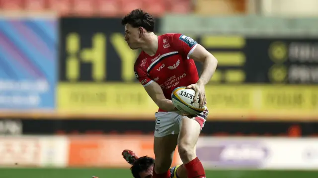 Tom Rogers of Scarlets makes a break past Mirko Belloni of Zebre