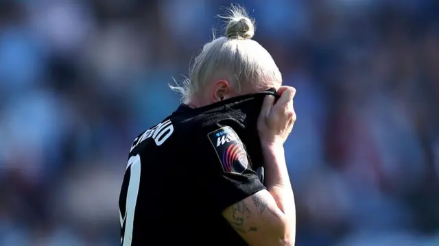England covers her face with her shirt