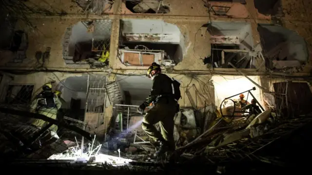 An Israeli soldier uses a torch to inspect the damage