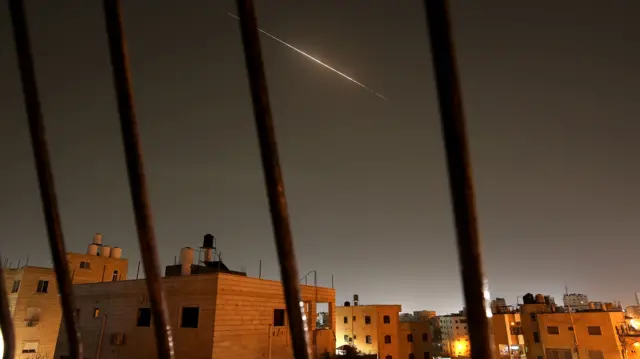A streak of bright light is seen in a dark sky above the city of Hebron in the West Bank.