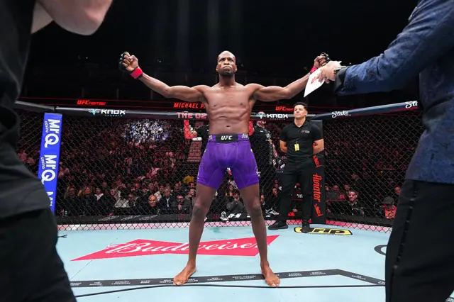 Michael Page opens up his arms in the centre of the octagon