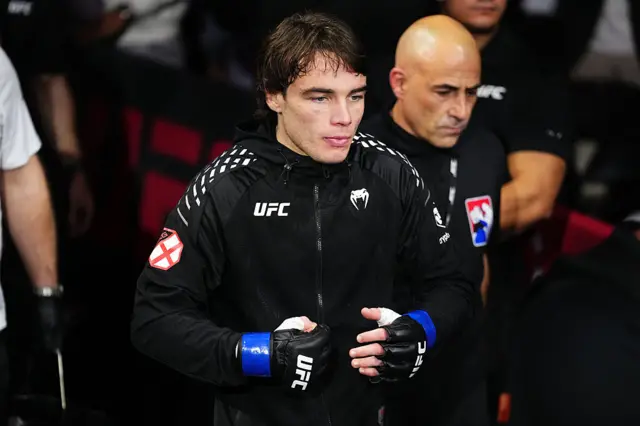Luke Riler wearing a black jacket and UFC gloves