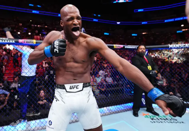Michael 'Venom' Page holds up his fist, stretches out his arm and sticks out his tongue