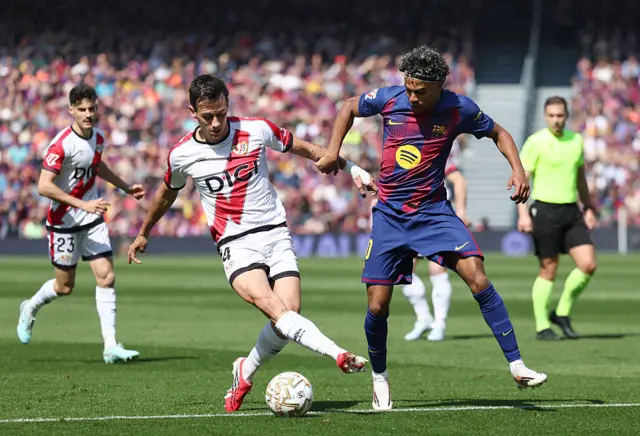 Rayo Vallecano's French defender #24 Florian Lejeune fights for the ball with Barcelona's Spanish forward #10 Lamine Yamal