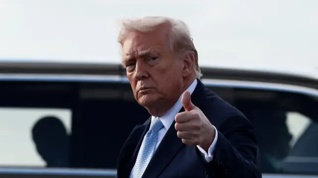 Donald Trump gestures as he steps from Air Force One upon his arrival in West Palm Beach.