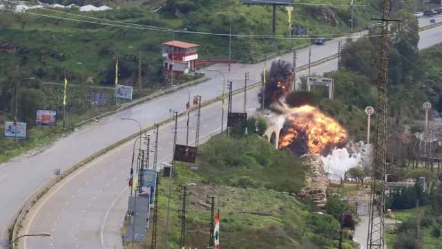 Wide shot capturing the moment an explosion goes off from under a road bridge over the Litani river in Lebanon