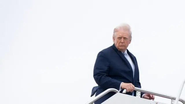 Donald Trump looks over his shoulder as he boards Air Force One