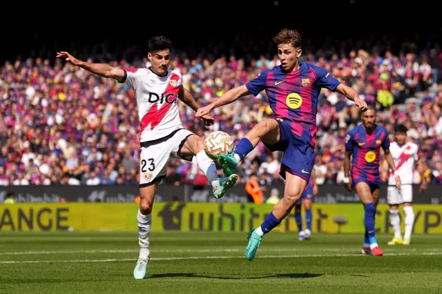 Oscar Valentin of Rayo Vallecano is challenged by Fermin Lopez of FC Barcelona