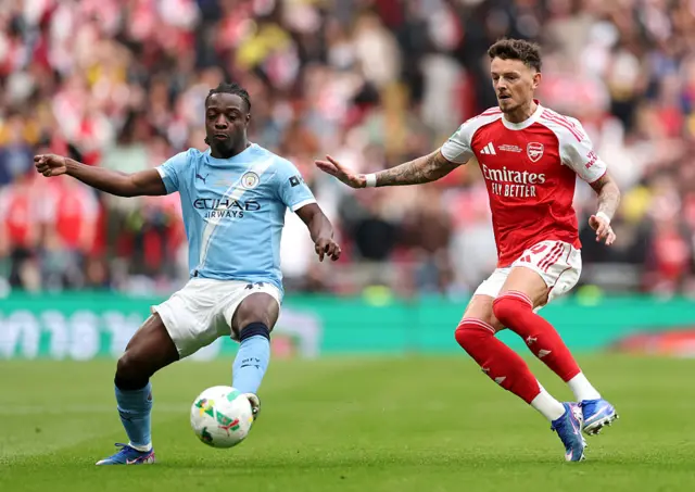 Jeremy Doku controls the ball whilst under pressure from Ben White