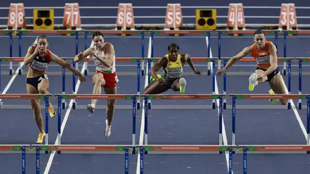 Athletes compete in the women's semi-final 60m hurdles heat 1