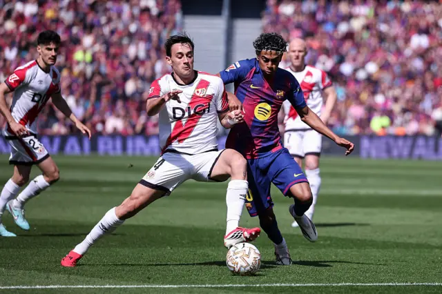 Lamine Yamal of FC Barcelona and Pedro Diaz of Rayo Vallecano in action