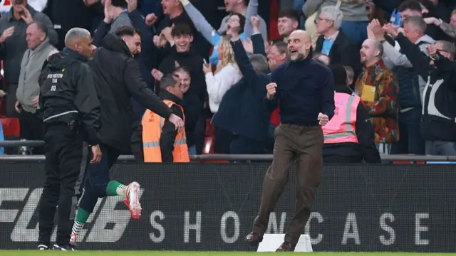 Pep Guardiola celebrates on the touchline