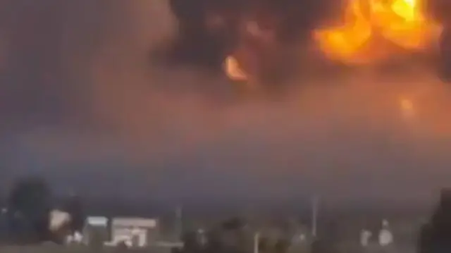 A screengrab from the video showing a massive fireball erupting from the naval base