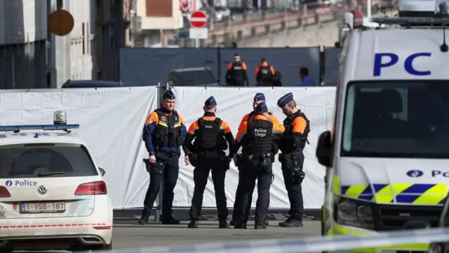 Police secure the site near a synagogue damaged by an explosion in Liège, 9 March