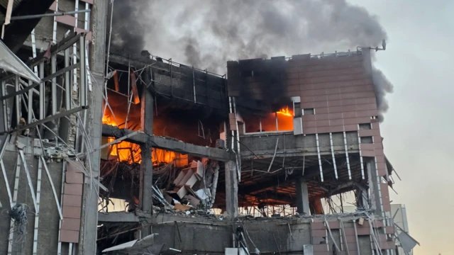 Extensive damage and a fire burning inside the building hit by an apparent air strike in Tehran on Monday morning