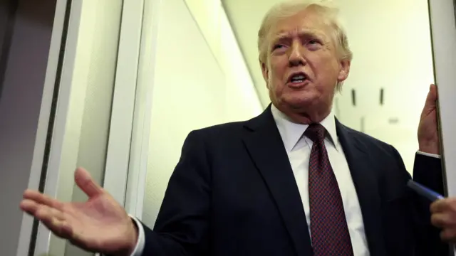 U.S. President Donald Trump speaks to reporters aboard Air Force One on a flight back to Washington March 15, 2026.