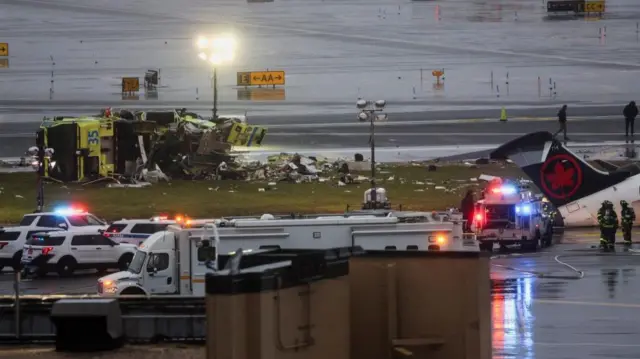 Debris from the upturned vehicle surrounded by emergency vehicles