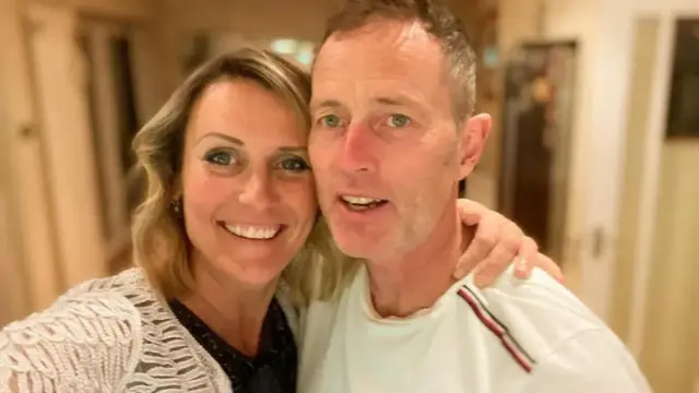 Craig and Lindsay Foreman standing close together smiling at the camera