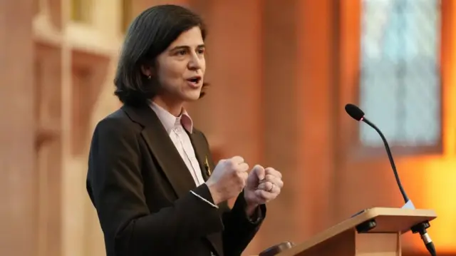 Sarah Sackman KC MP speaks at a podium during the CCIG (Criminal Courts improvement Group) conference at the Guildhall, in central London, while standing at a podium and wearing a dark coloured blazer.