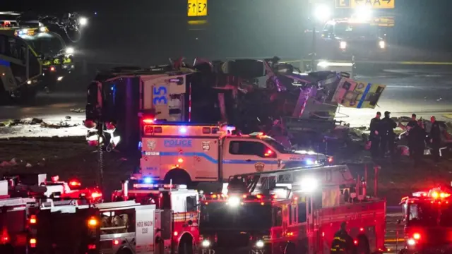 Emergency crews work around a ground vehicle following a collision between the vehicle and an Air Canada Express jet at New York's La Guardia Airport in Queens, New York.