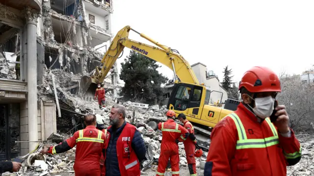 Emergency personnel work at the site of a strike on a residential building, amid the U.S.-Israeli conflict with Iran, in Tehran, Iran, March 23, 2026.