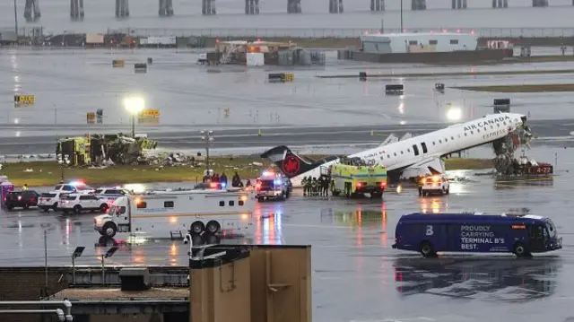 The damaged plane and crashed vehicle on the tarmac at LaGuardia Airport
