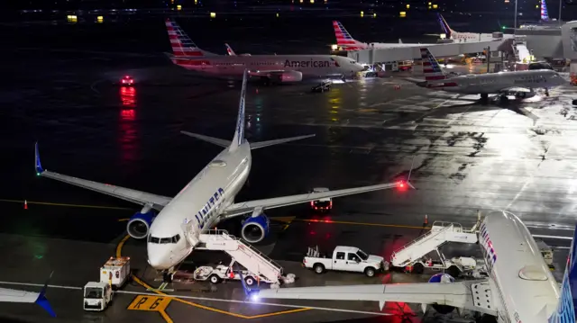 Planes sit on the tarmac at night time