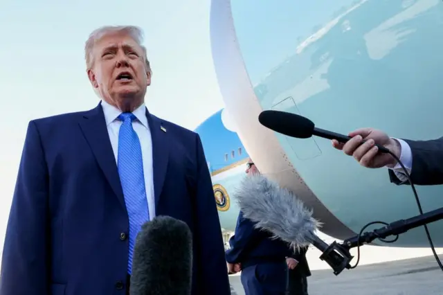 Donald Trump stands very close to the engine of Air Force One while speaking to reporters