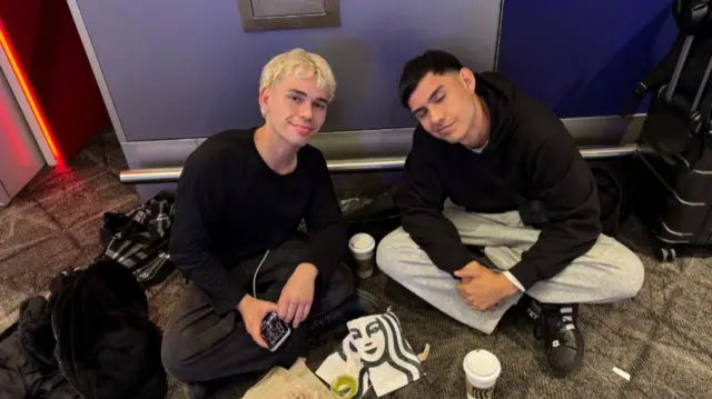 Two boys sit on the floor