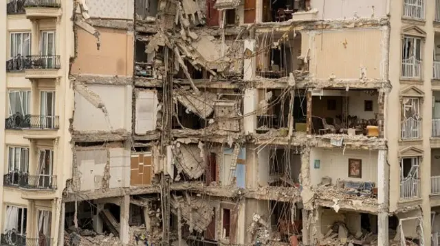 A damaged residential building with blown out walls