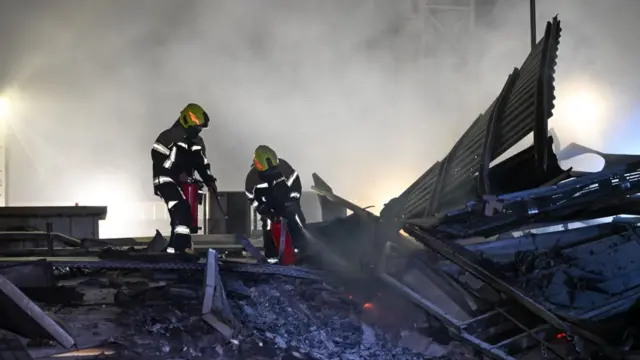 Emergency workers pictured at site of fire in Bahrain, working to extinguish it