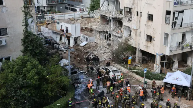 Israeli emergency workers at the site of a missile attack