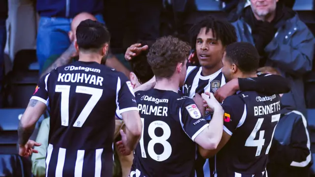 Tom Iorpenda stands in a huddle with his arm around team-mate Keanan Bennetts as he celebrates a goal