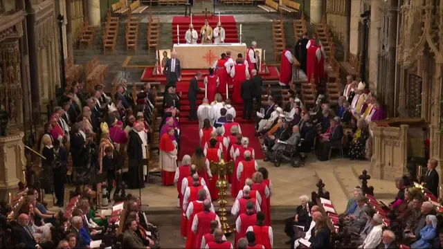 Clergy men and women walk down the centre of Canterbury cathedral