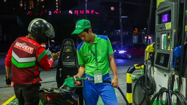 A worker refills a motorcycle with petrol at a gas station, after Philippines President Ferdinand 'Bongbong' Marcos Jr. declared a state of national energy emergency, in Metro Manila.