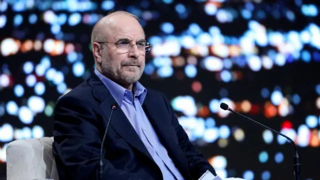 Mohammad Bagher Ghalibaf sits in a television studio next to two microphones in 2024