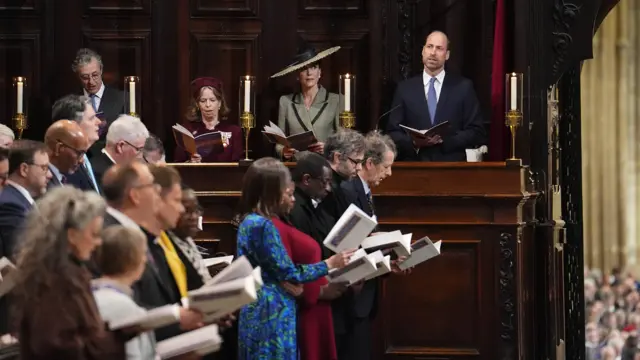 The Prince and Princess of Wales look on while holding hymn books as congregation sings