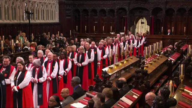 A line of religious officials wait inside Canterbury Cathedral