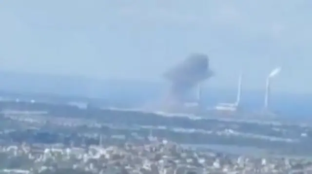 A smoke cloud seen at the power station which has three chimney stacks